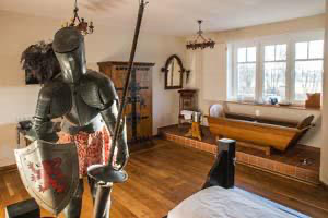 De middeleeuwse junior suite met hemelbed en houten badkuip in het themahotel Beverland bij Münster.