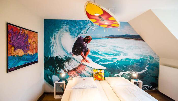 Muurbehang in de surfer themakamer in Hotel Beverland bij Münster en Osnabrück