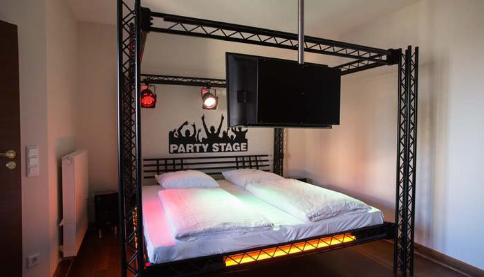 Het kleurrijk verlichte discobed in de disco-themakamer in het themahotel Beverland bij Münster en Osnabrück.
