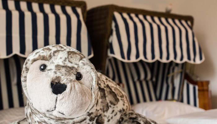 Een zeehond naast een strandstoel in de Noordzee Themakamer in het hotel in de buurt van Münster en Osnabrück