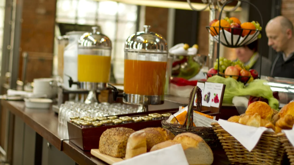 Frühstücksbuffet mit Brötchen, Obst, Säften und weiteren Speisen
